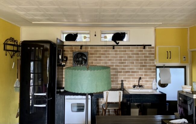 キッチンの壁を踏み台にして天窓にいる2匹の猫の様子を撮影した写真