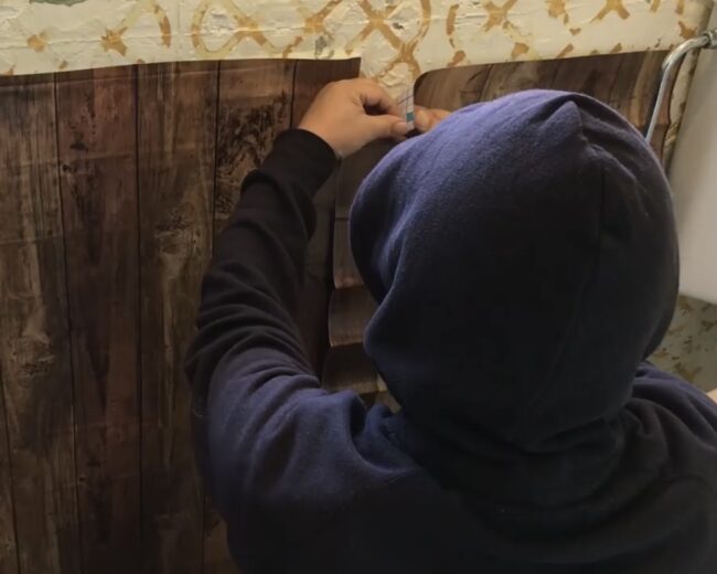 ダイソーのリメークシートをトイレの壁に貼っている様子を撮影した写真